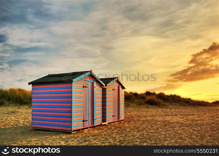 A golden sunrise illuminates traditional British beach huts at Great Yarmouth, in England.