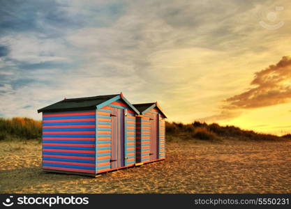 A golden sunrise illuminates traditional British beach huts at Great Yarmouth, in England.