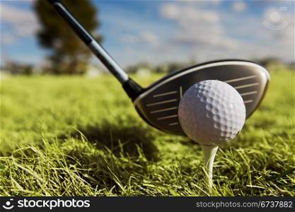 A golf ball and driver with focus on the ball