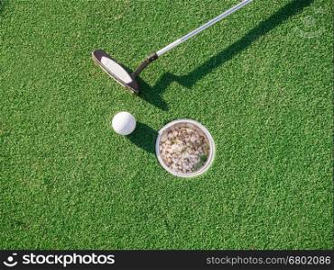 A golf club and a ball during a mini golf game