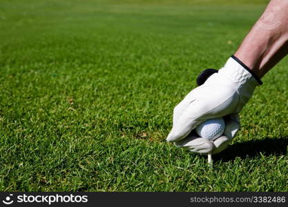 A golfer sets up a tee at a driving range