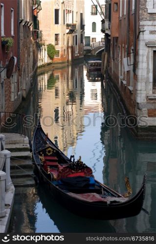 A gondola moored beside a set of stairs on a canal, Venice, Italy