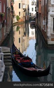 A gondola moored beside a set of stairs on a canal, Venice, Italy