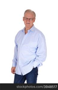 A good looking senior man with glasses standing in a blue shirt with onehand in his jeans pocked, isolated for white background.