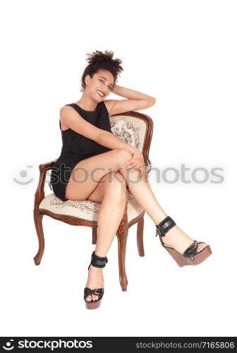 A gorgeous multi-racial woman sitting in a short summer dress in an old armchair, with her curly black hair, isolated for white background