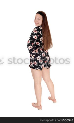 A gorgeous young teenage girl standing with long brunette hair from the back looking over her shoulder, isolated for white background