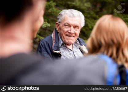A grandfather talking a group of grandchildren