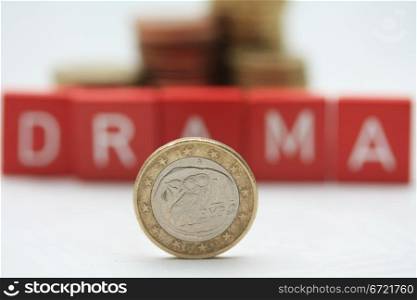 "A greek euro coin in front of letters spelling the word "drama", expressing the financial crisis and problems in Greece"