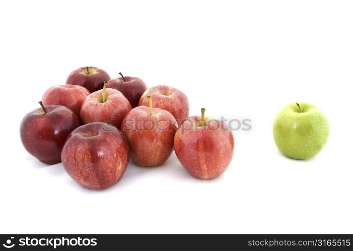A green apple is separated from the rest
