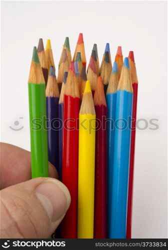 a green color pencil is chosen from a group of art supplies