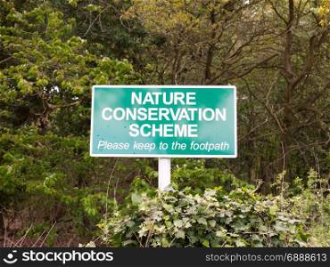 a green sign outside saying nature conservation scheme for graphic resources