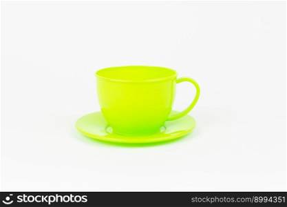 a green toy plastic cup with a plate on a white background. green toy plastic cup with a plate on a white background