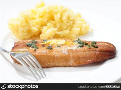 A grilled kipper garnished with herbs and a dab of butter, served with mashed boiled potatoes