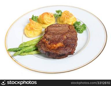 A grilled ribeye steak served with asparagus, duchesse potatoes, and a parsley garnish.