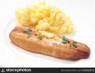 A grilled smoked herring or kipper, garnished with herbs and a dab of butter, served with mashed boiled potatoes