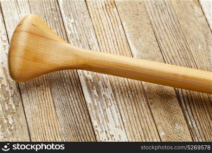 a grip of wooden canoe paddle against grunge painted white wood background