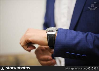 a groom is Getting Ready and showing watches