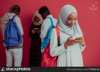 A group of African Muslim students with backpacks posing on a pink background. the concept of school education. High-quality photo. A group of African Muslim students with backpacks posing on a pink background. the concept of school education.