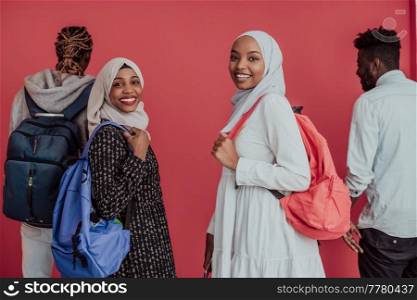 A group of African Muslim students with backpacks posing on a pink background. the concept of school education. High-quality photo. A group of African Muslim students with backpacks posing on a pink background. the concept of school education.