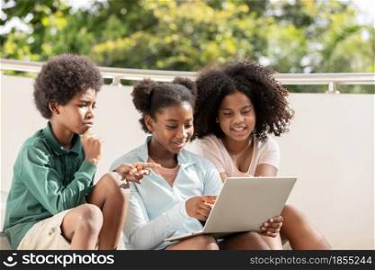 A group of afro children curly hair style conversation conversation and using laptop at staircase of building.