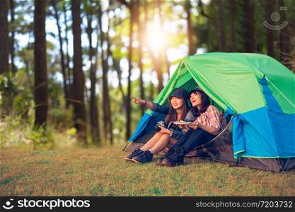 A group of Asian friends tourist drinking together with happiness in Summer while having camping