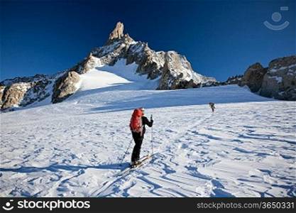A group of backcountry skiers walks up to the Dent du Geant, Mont Blanc massif, Chamonix, west Alps, France, Europe.