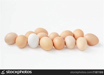 A group of brown eggs white background. Getting ready for the Easter holiday. One leader among all.. A group of brown eggs white background. Getting ready for the Easter holiday.