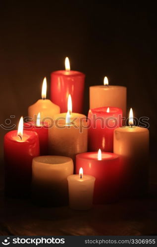 A group of burning candles in red and white