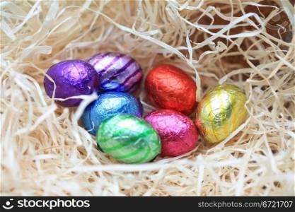 A group of colored eggs in a nest