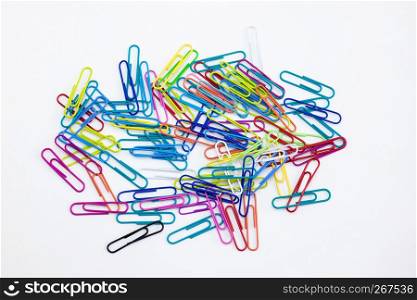 A group of colorful paper clips random stack on white background. Stationery office supplies concepts.