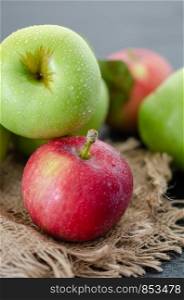A group of different colors of apples on a black table. Vertical and close up format.