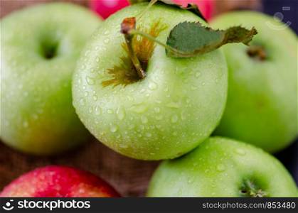 A group of different colors of apples on a black table. Horizontal and close up format.