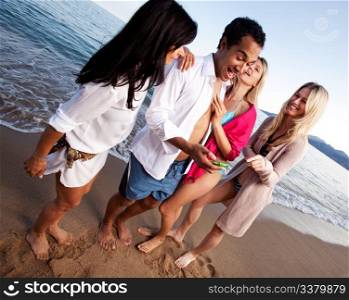 A group of friends having fun at the beach, looking at a cellphone