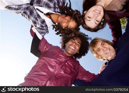 A group of friends hugging and looking down on the camera