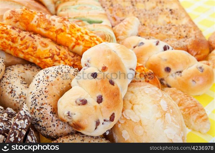 A group of international breads, including Almond Bun, Buko Pandan Loaf, Italian Cheese Sticks, & Pumpernickel.