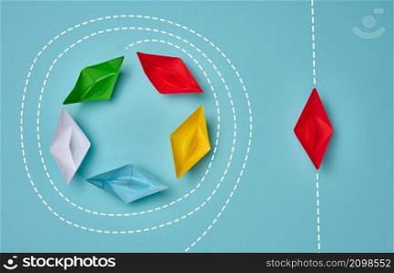 a group of paper boats floats in a circle, another red floats in a straight line. Strong leader concept, different vision, strong business. Looping over an idea