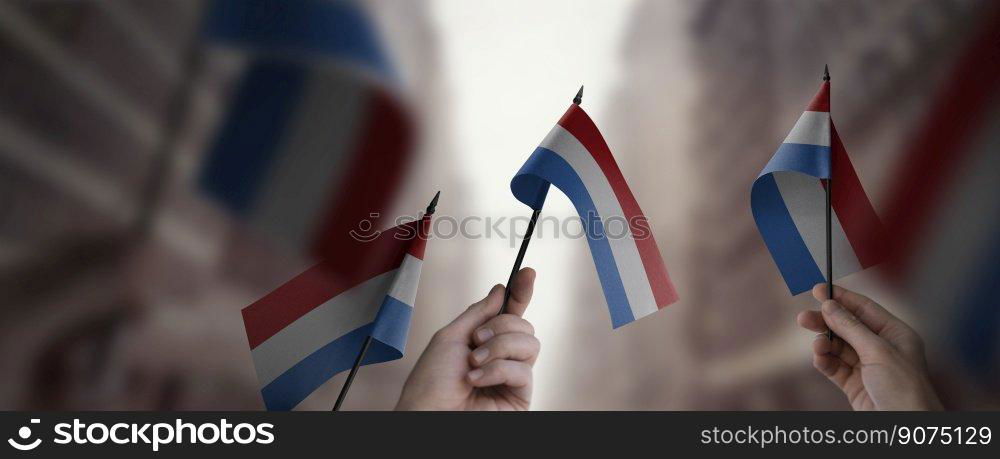 A group of people holding small flags of the Netherlands in their hands.. A group of people holding small flags of the Netherlands in their hands