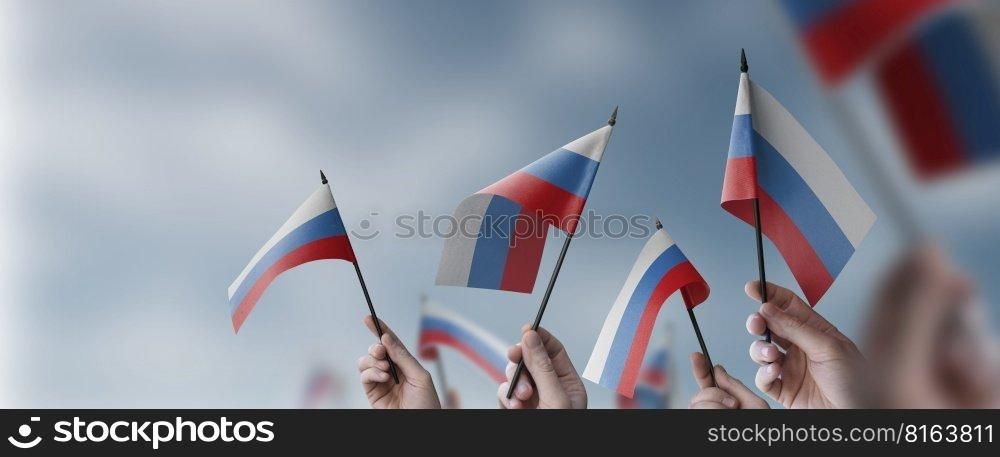 A group of people holding small flags of the Russia in their hands.. A group of people holding small flags of the Russia in their hands