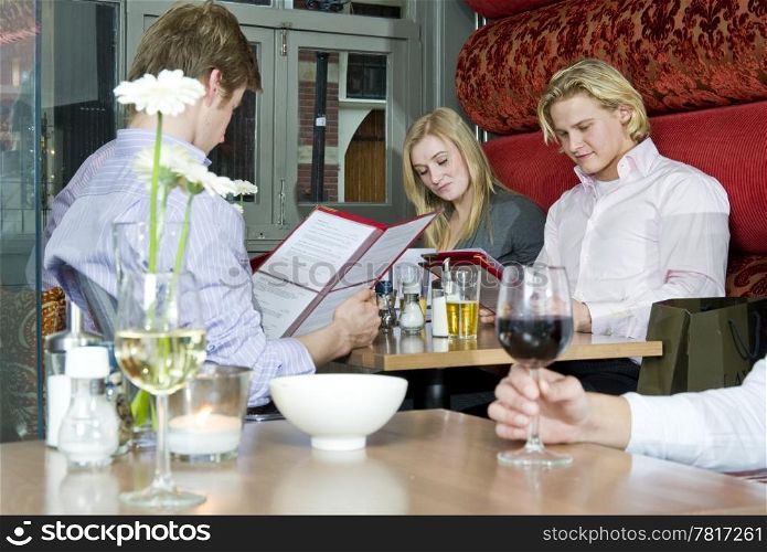 A group of people looking at the menu in a restaurant
