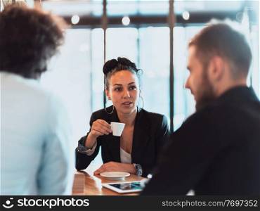 A group of people on a coffee break use laptops, tablets, and smartphones while talking about new business projects. A group of people on a coffee break use laptops, tablets and smartphones while discussing new business projects. business concept.