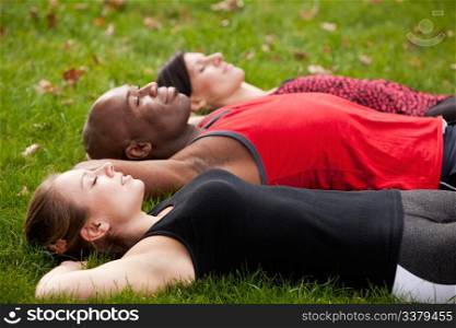 A group of people relaxing in a park after exercise