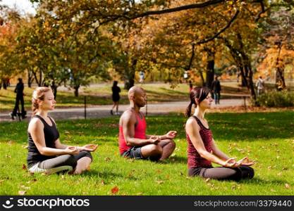 A group of people relaxing with meditation in a city park