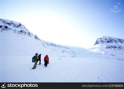 A group of people treking across a winter landscape