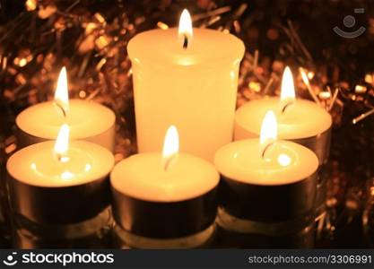 A group of white, burning votive lights and some christmas decoration