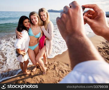 A group of women having their picture taken by a camera phone. Shallow depth of field, focus on women.