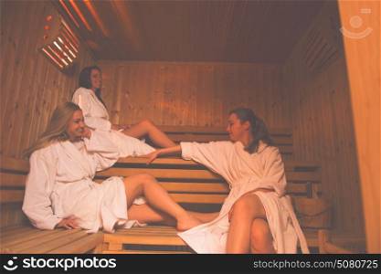 a group of young beautiful women enjoys relaxing in the sauna in the modern spa salon