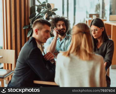 a group of young entrepreneurs on a coffee break discuss the project while using modern editing tablets, a smartphone and a laptop. a group of young entrepreneurs on a coffee break discuss the project while using modern editing tablets, a smartphone and a laptop.Business concept