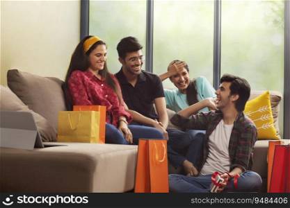 A Group of youngsters talking happily in a room after a shopping spree.