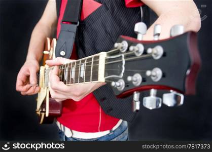 A guitarist working the fretboard and strings. Selective focus on the musicians left hand