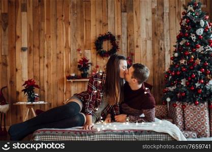 a guy and a girl celebrate the new year together  in a warm atmosphere and give each other gifts